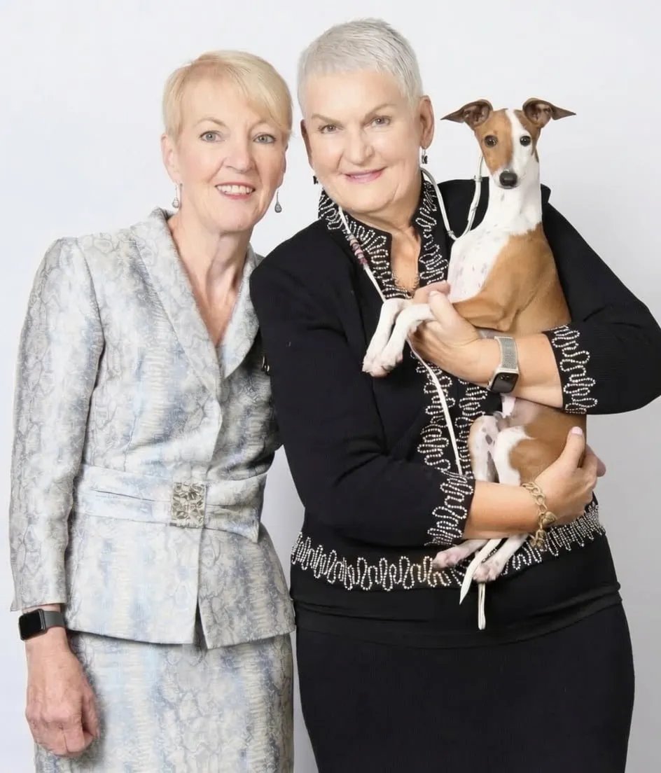 Sandy Reeve and Tina Clift standing together, one of them holding a fawn and white Italian Greyhound